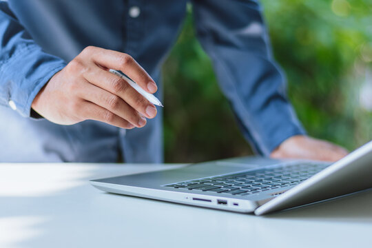 Businessman Hand Pointing Pen at Laptop - Online Advisory, Virtual Mentorship, Remote Executive Guidance, Software Demo, and Corporate Solution Pitch Concept