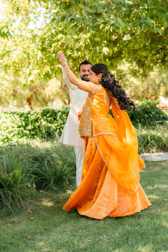 couple dancing outside in forman indian dress