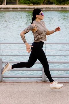 Latina athlete doing a focused morning workout by a park lake