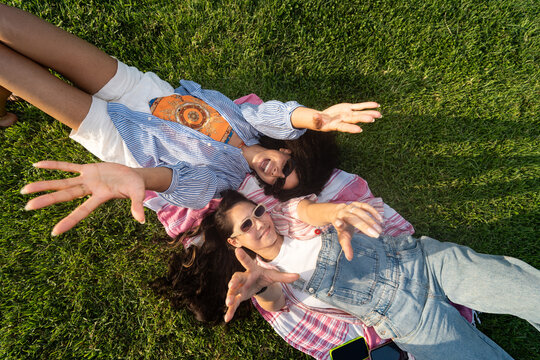 Friends Enjoying a Sunny Day on the Grass in the Park