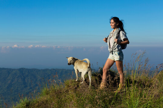 Female hiker with local dog on mountain ridge