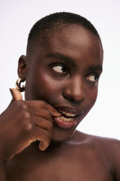 Model Poses With Hand on Face in Studio Setting
