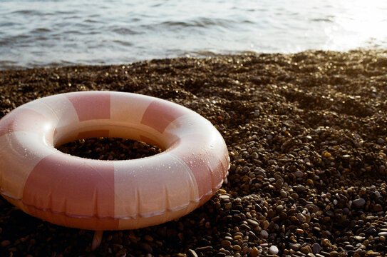 Pink and white life ring on a seashore