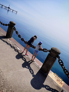 Two young girls look out over the water