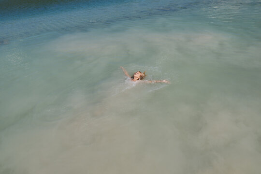 Preteen child swimming in white silt clouds