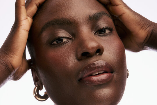 Woman Posing With Hands on Head in Studio Setting