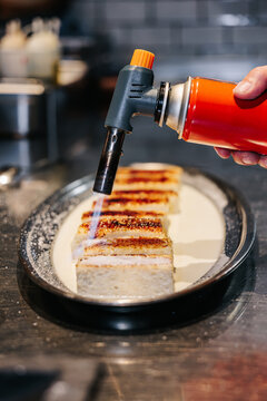 Chef caramelizing dessert with torch