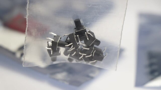 Tactile push-button switches with metal leads, packed in a clear plastic bag