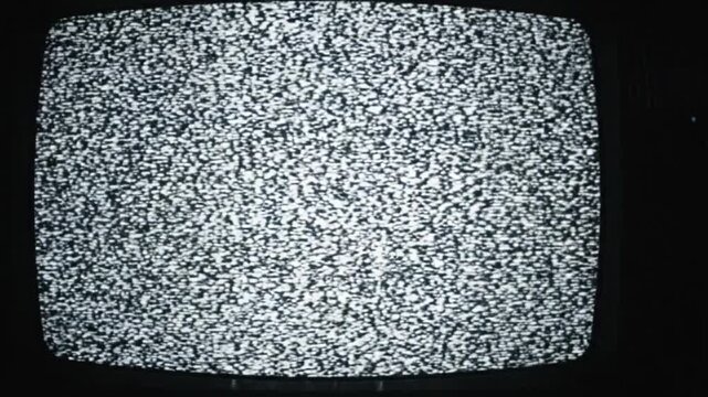 Vintage CRT television screen displaying analog static noise and signal interference in a dark room.