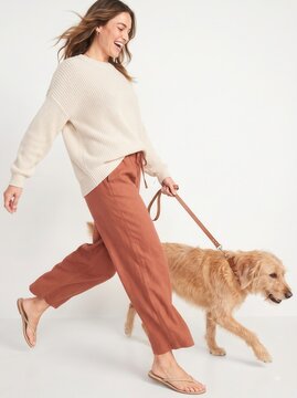 Happy young woman in casual activewear walking her cute fluffy dog on a leash, full length isolated on white background.-1