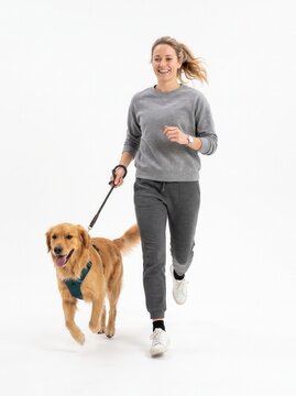 Happy young woman in casual activewear walking her cute fluffy dog on a leash, full length isolated on white background.-1