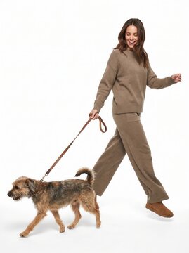 Happy young woman in casual activewear walking her cute fluffy dog on a leash, full length isolated on white background.-1