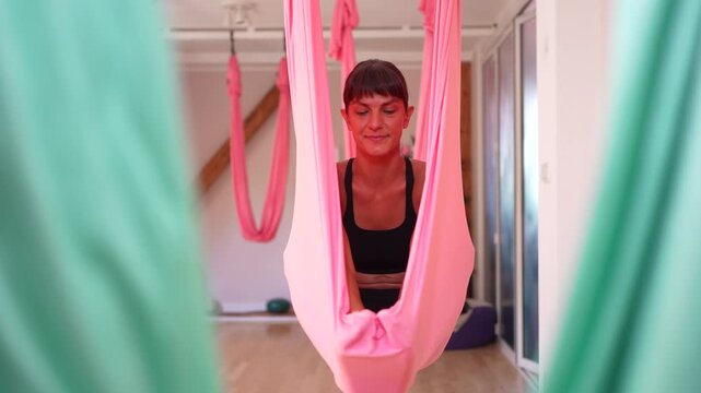 Woman relaxing in aerial yoga hammock