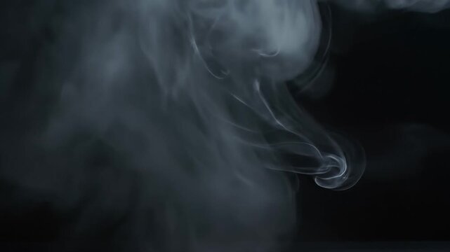 Mysterious dark background with wisps of white smoke rising from bottom