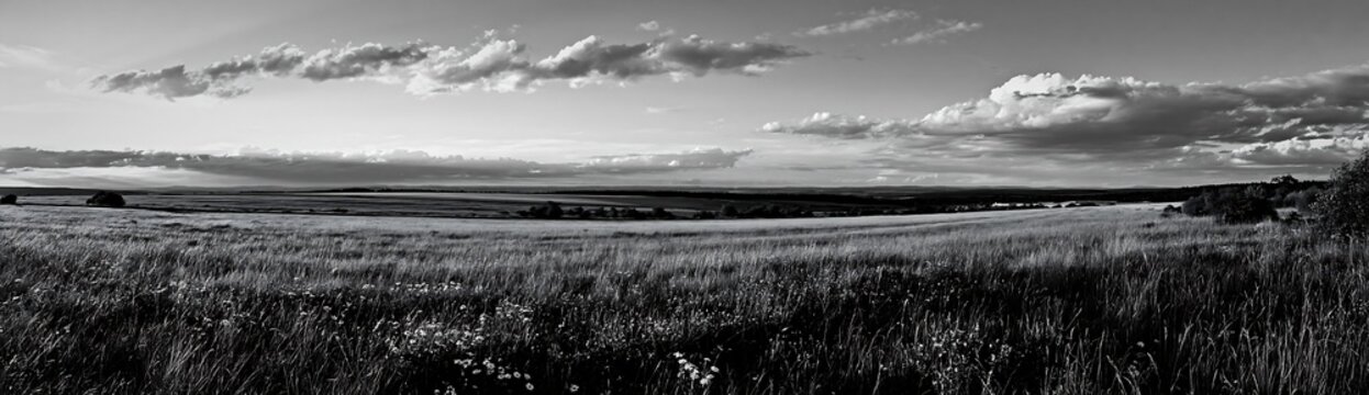 Black and white german foothill meadow at sunset with rolling hills and clouds