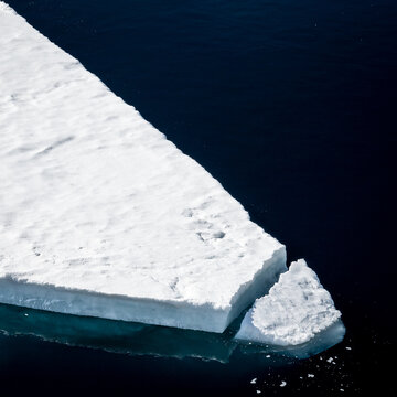Triangular ice floe edge against dark water