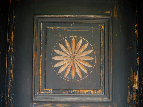 Antique Wooden Door with Golden Geometric Sun Ornament Close-up Details