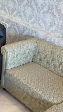Tufted Fabric Sectional Sofa View Living Room Interior. Vertical video revealing a beige tufted couch lounge against decorative wallpaper. Ideal for home decor ads.