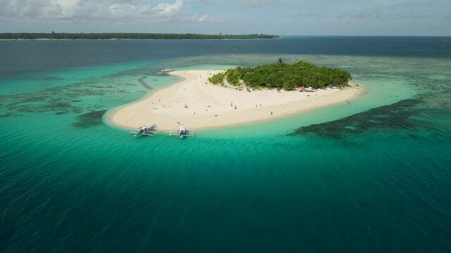 Aerial drone view of Inaladelan Island in Port Barton, Palawan, Philippines, featuring a white sand beach and crystal-clear tropical waters.