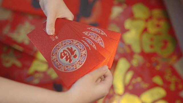 Hands Holding Red Chinese Envelopes for Lunar New Year Celebration in China