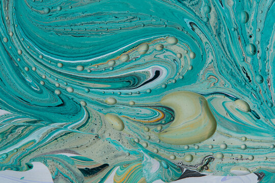 Dynamic turquoise paint waves with smooth pale yellow liquid drops and bubble details.