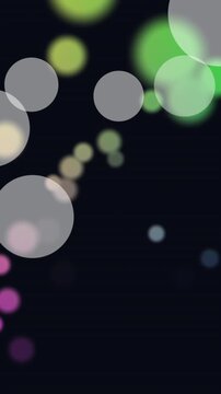 Animation of white and colorful spots of light floating against black background