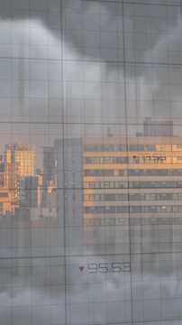 Animation of multiple falling graphs over dense clouds and modern cityscape against sky