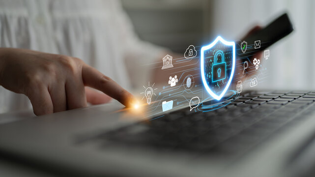 Person Engaging with Laptop while Digital Shield Icon Represents Cybersecurity and Data Protection in Home Office Setting with Abstract Technology Elements. Entropy.