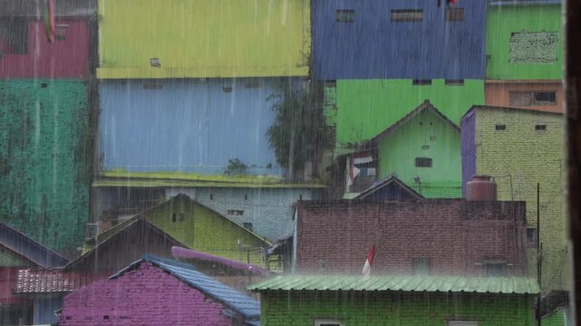 Heavy rain falling on the colorful painted houses of the rainbow village of jodipan, indonesia