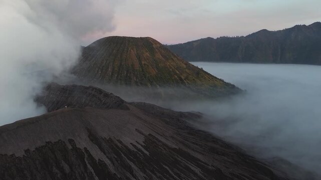 Aerial view of the active mount bromo volcano crater erupting in a sea of clouds in indonesia