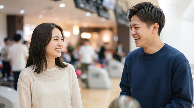 ボウリング場で楽しそうに会話する若いカップル
