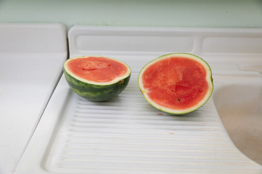 watermelon cut in half on white counter