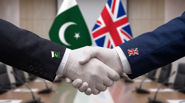 Business handshake between Pakistan and United Kingdom representatives in a meeting room.