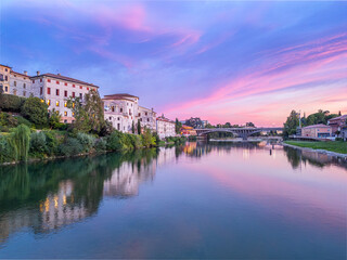 Obraz premium Aerial push in view of Ponte Generale Medici over Brenta river at sunset in Bassano del Grappa, Italy