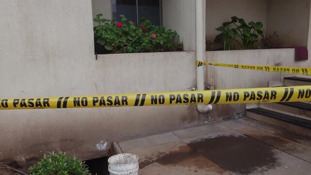 Cinta de precauci&oacute;n NO PASAR bloqueando el acceso a un edificio 