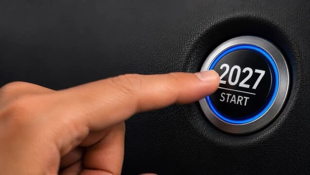 2027 start button pressed by hand represents New Year goals, business motivation, achievement and automotive new beginning. New Year start, Christmas holiday, future goals, business success, ambition.