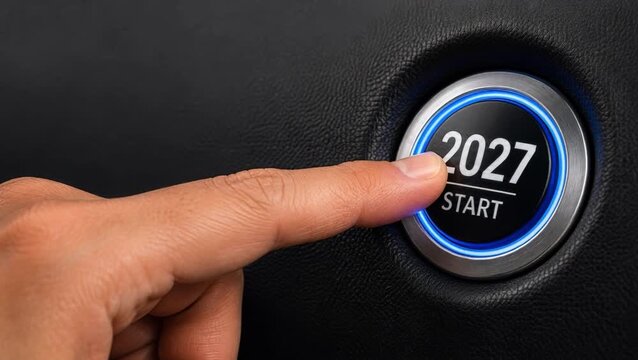 2027 start button pressed by hand represents New Year goals, business motivation, achievement and automotive new beginning. New Year start, Christmas holiday, future goals, business success, ambition.