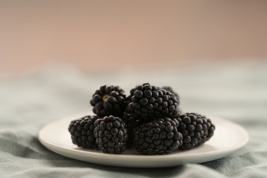 fresh ripe blackberry on a white saucer