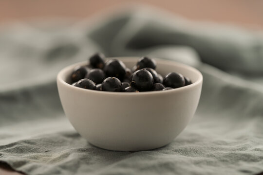 ripe blackcurrant in white ceramic bowl