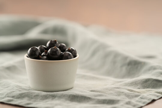 ripe blackcurrant in white ceramic bowl