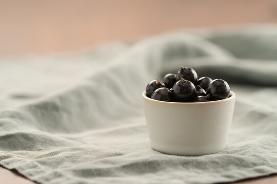 ripe blackcurrant in white ceramic bowl