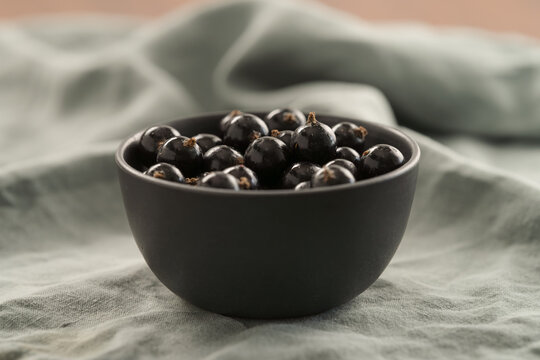 ripe blackcurrant in black ceramic bowl