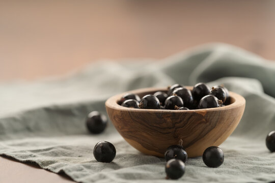 ripe blackcurrant in wood ceramic bowl