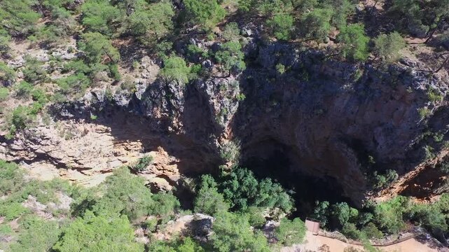 Antalya Guver Canyon aerial drone view shows deep rocky gorge cliffs, karst cave, rugged valley. Birds eye scene reveals ravine escarpment, chasm limestone formation, natural fissure landscape.