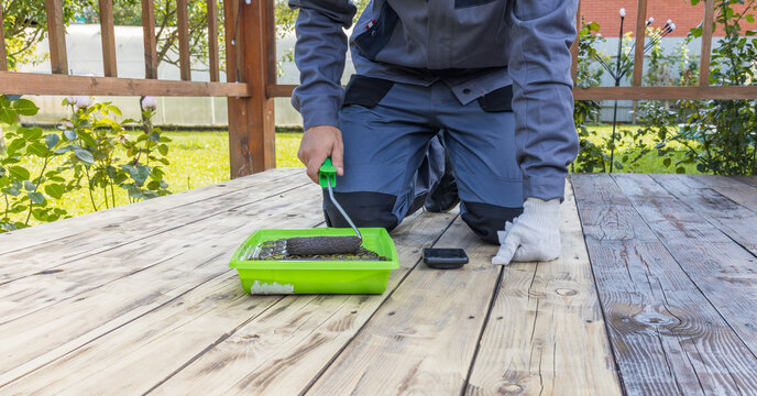 Homeowner staining wooden deck