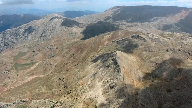 Taurus Mountains near Antalya, Turkey show maquis terrain, rocky slopes, and sparse summer shrubs. Mediterranean geography and dry ridges create a rugged warm highland scene.