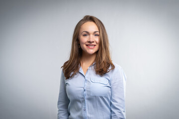 Fototapeta premium Young professional woman smiling headshot on gray background