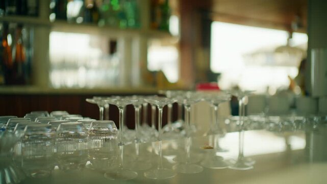 Close-up of empty wine and cocktail glasses on a bar counter with bottles behind, Cannes, France