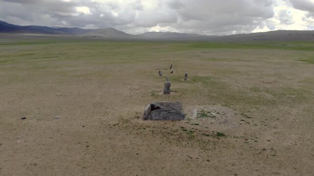 Ancient ritual burial site with deer stones and balbal monuments across Central Asian steppe. Prehistoric stele records nomadic belief, funerary custom, archaeological value, early Eurasian heritage.