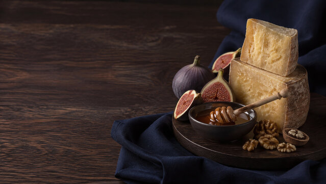 Aged artisan cheese figs and honey on dark oak